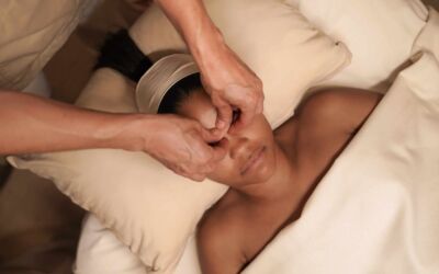 Person entspannt bei einer Gesichtsmassage auf einem Wellnessbett.