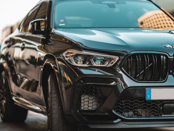 Nahaufnahme eines eleganten schwarzen BMW, der auf einer Straße parkt und modernes Automobildesign präsentiert.