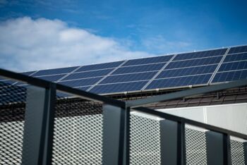 Nahaufnahme moderner Solarpanels auf einem Dach vor einem klaren blauen Himmel, der saubere Energie darstellt.