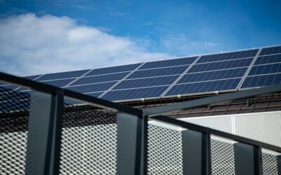 Nahaufnahme moderner Solarpanels auf einem Dach vor einem klaren blauen Himmel, der saubere Energie darstellt.